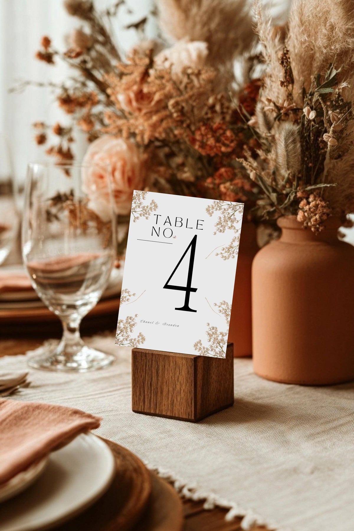 Wedding table number card on wooden stand with botanical border and large number