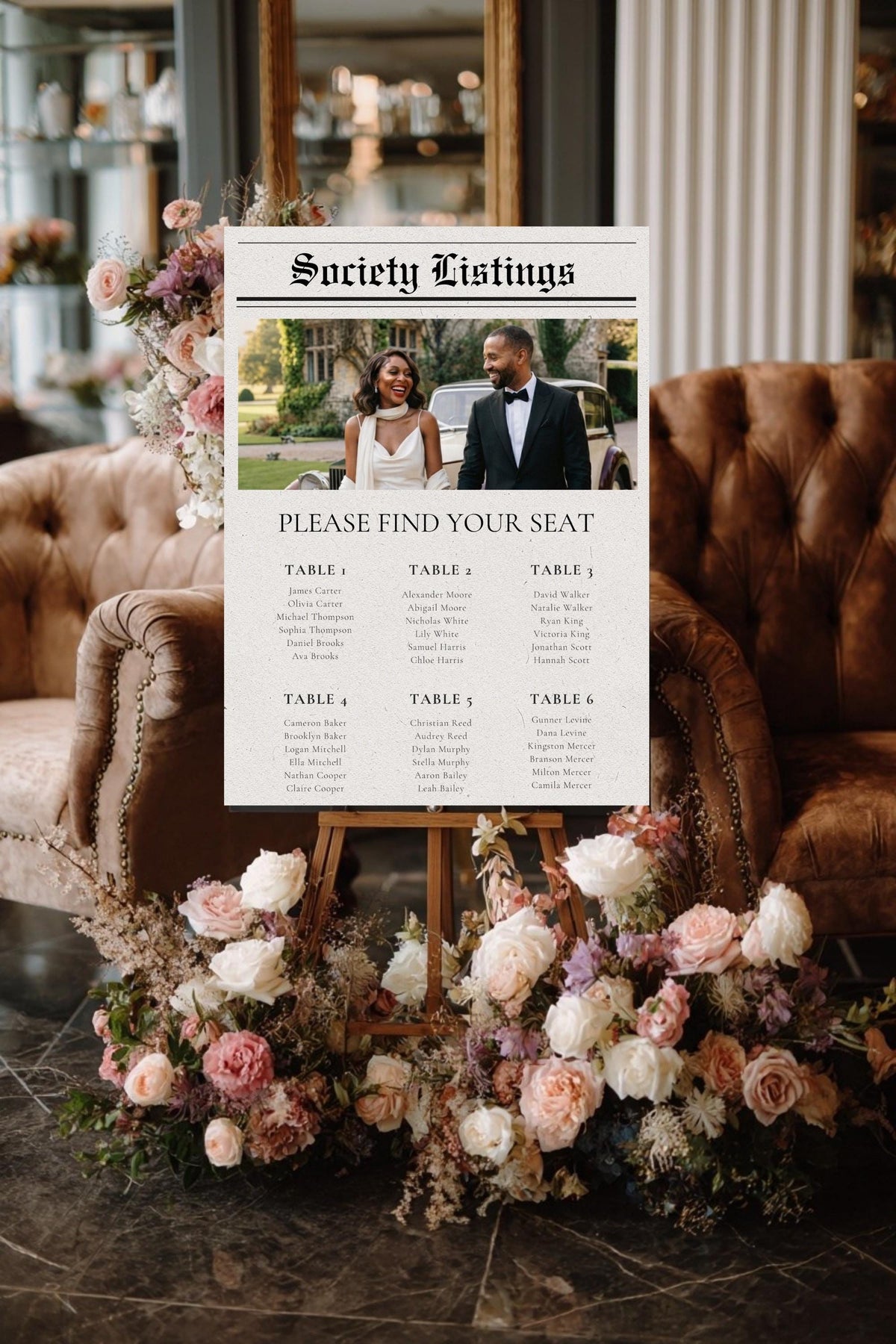 Newspaper-style wedding seating chart poster with photo header, surrounded by pink flowers