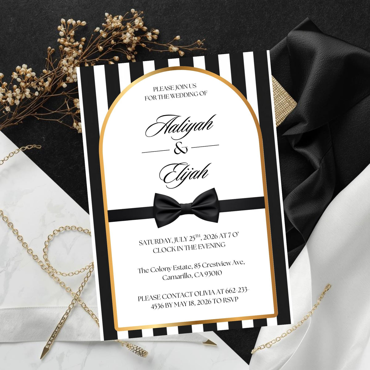Black-and-white striped wedding invitation with gold border and black bow detail
